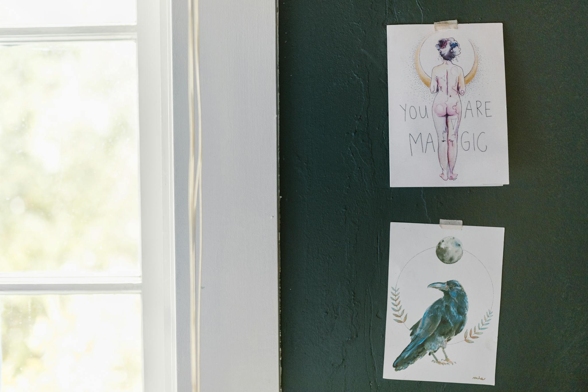 Two artistic posters with inspiring messages displayed on a dark green wall.
